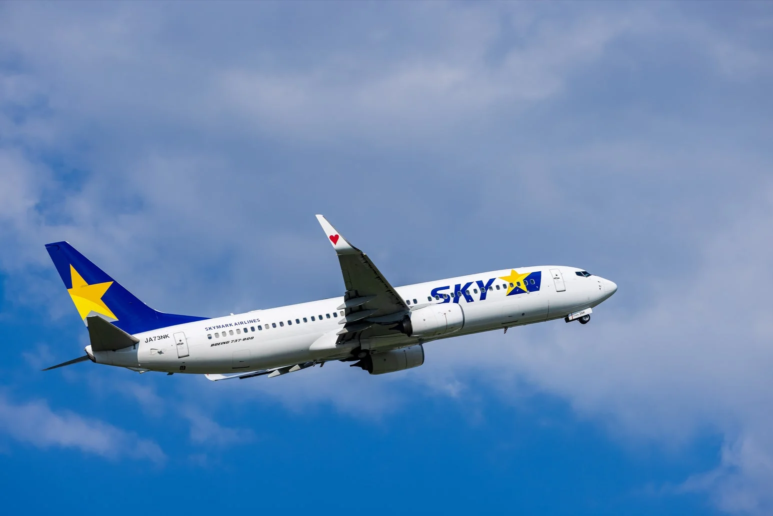 青い空と白い雲を背景に、スカイマークエアラインズのボーイング737-800型機