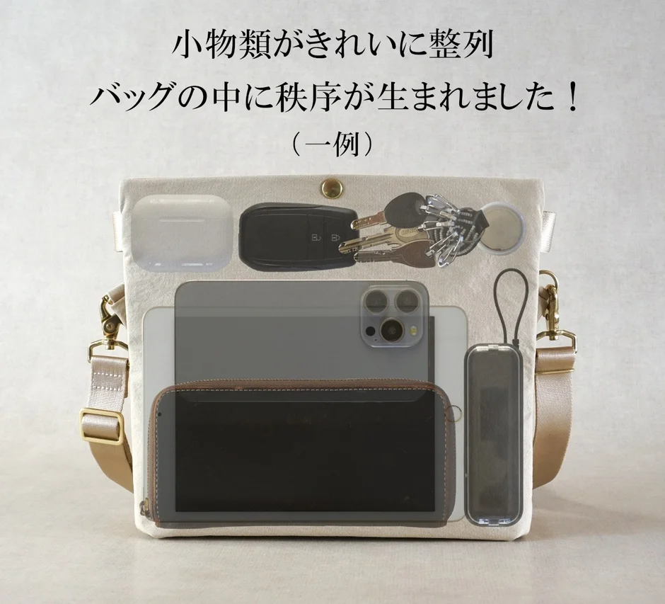 バッグの中に、タブレット、スマートフォン、財布、鍵、イヤホンなどの小物類が機能的にきれいに整列している様子