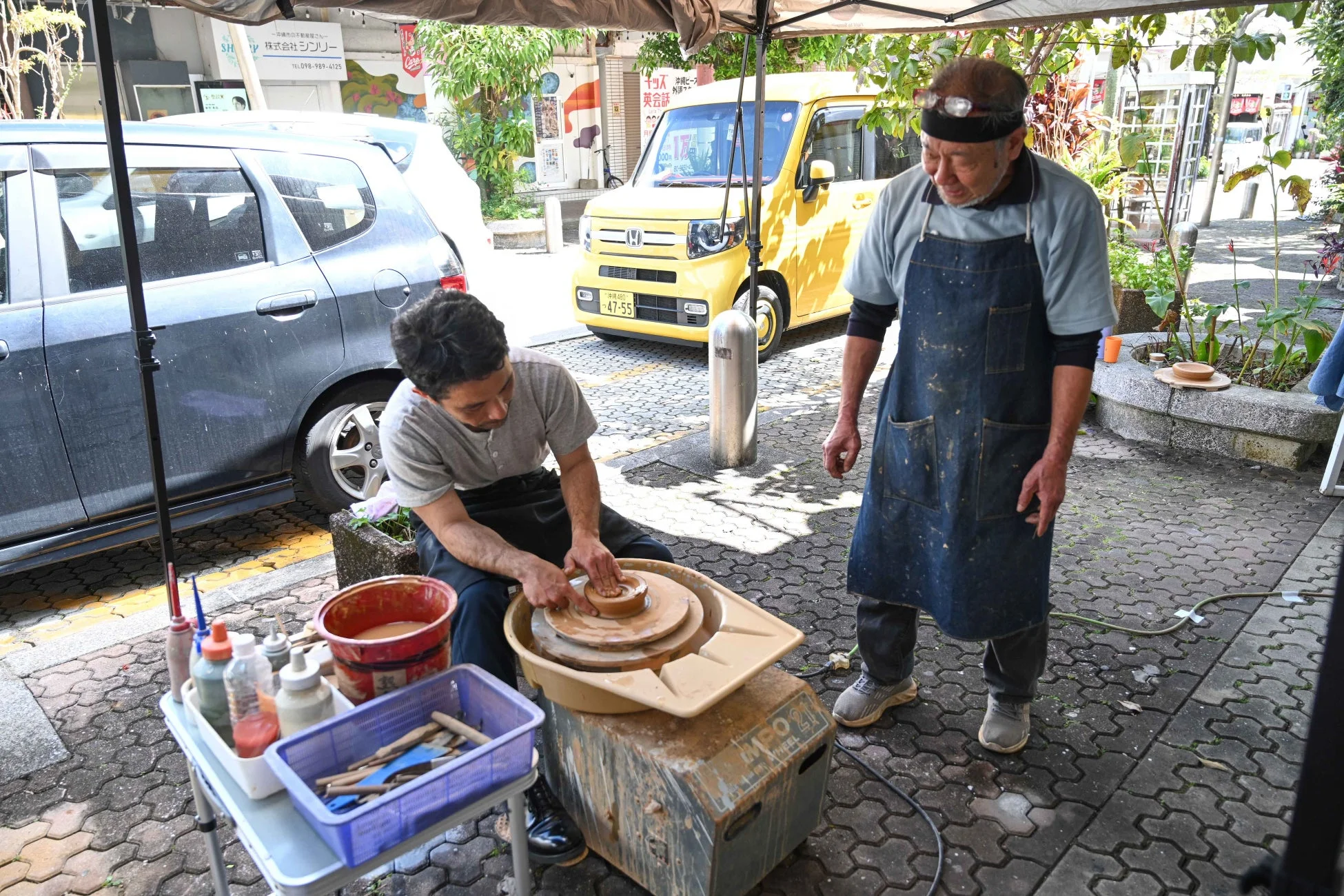 屋外で男性が電動ろくろを使って陶器を制作