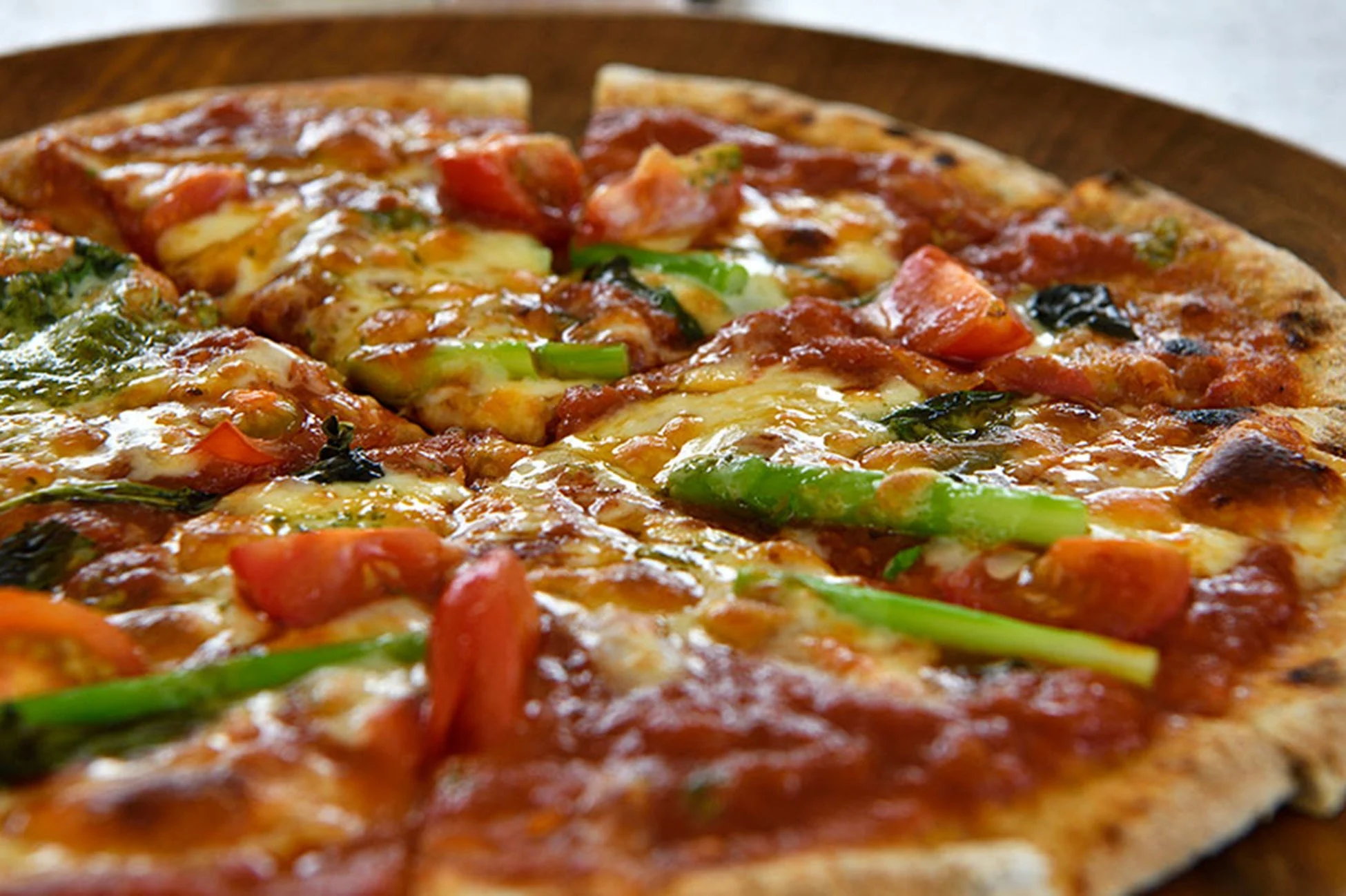 焼きたてのピザが木製のプレートに置かれている