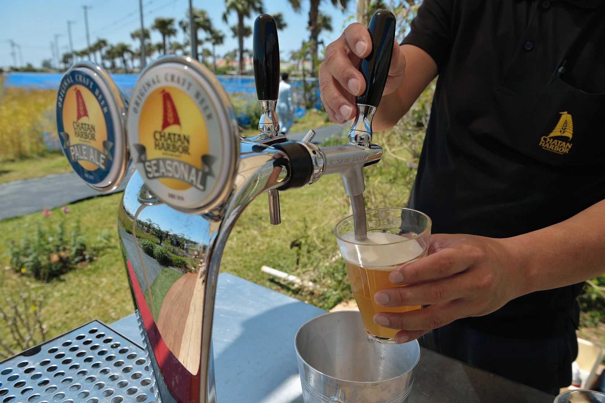 屋外でビールサーバーからグラスにクラフトビールを注ぐ様子