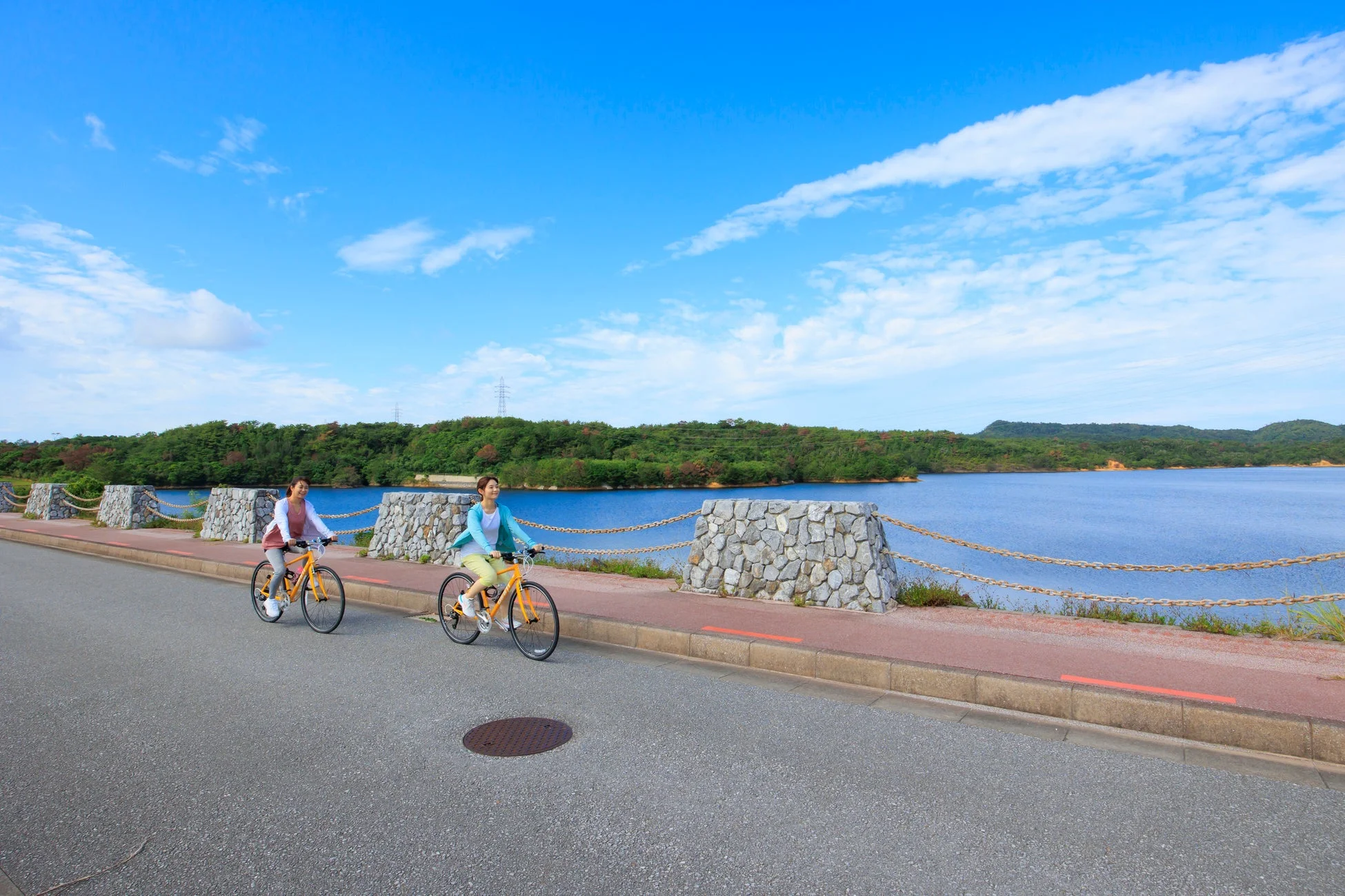 湖畔をサイクリングする二人
