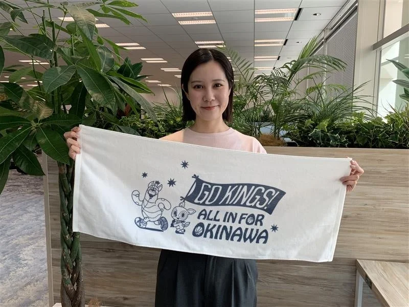 タオルを掲げる担当者