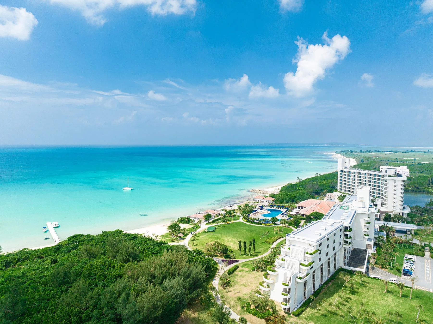 広大なターコイズブルーの海と白い砂浜、ホテル群