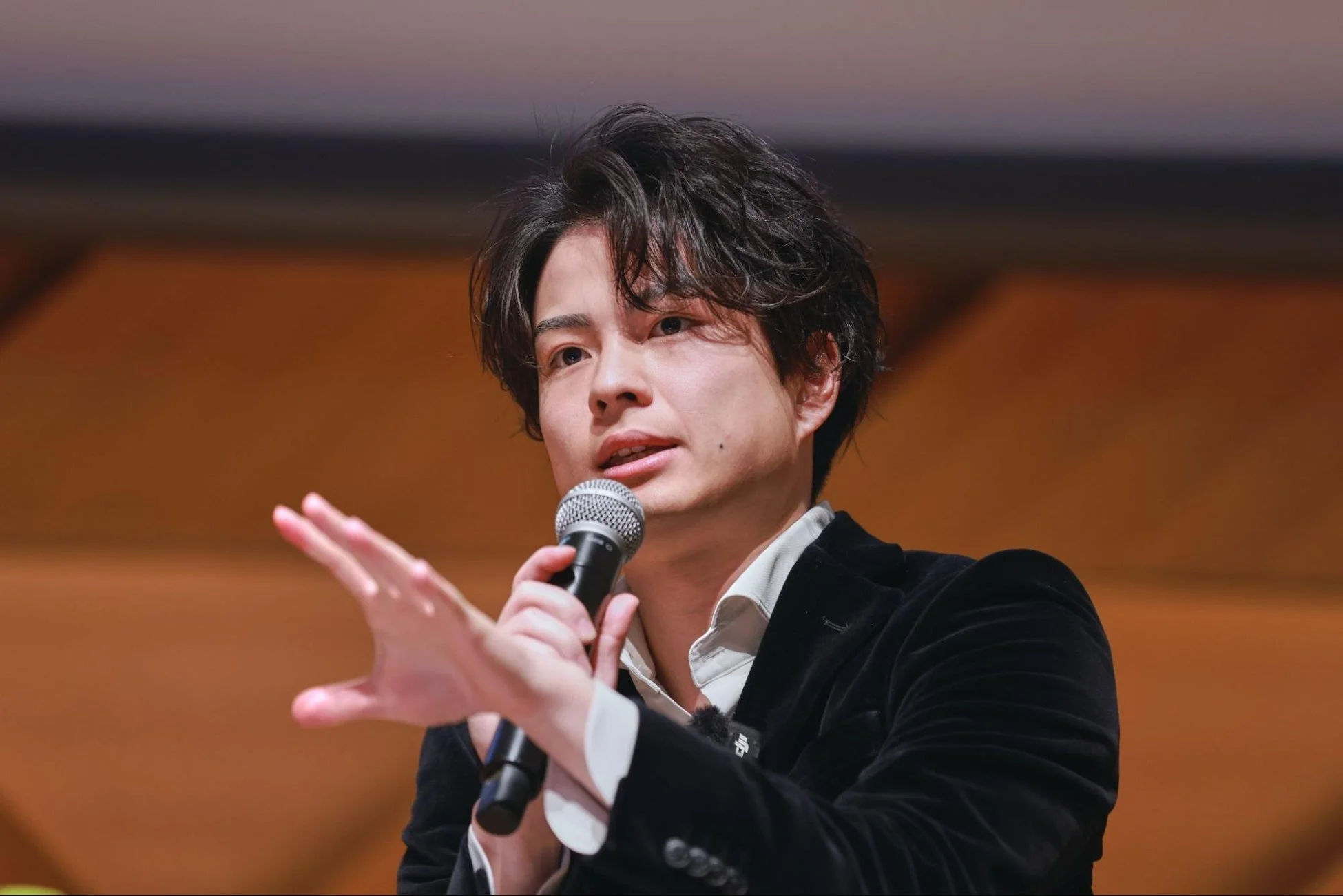 男性がマイクで熱心に話している様子