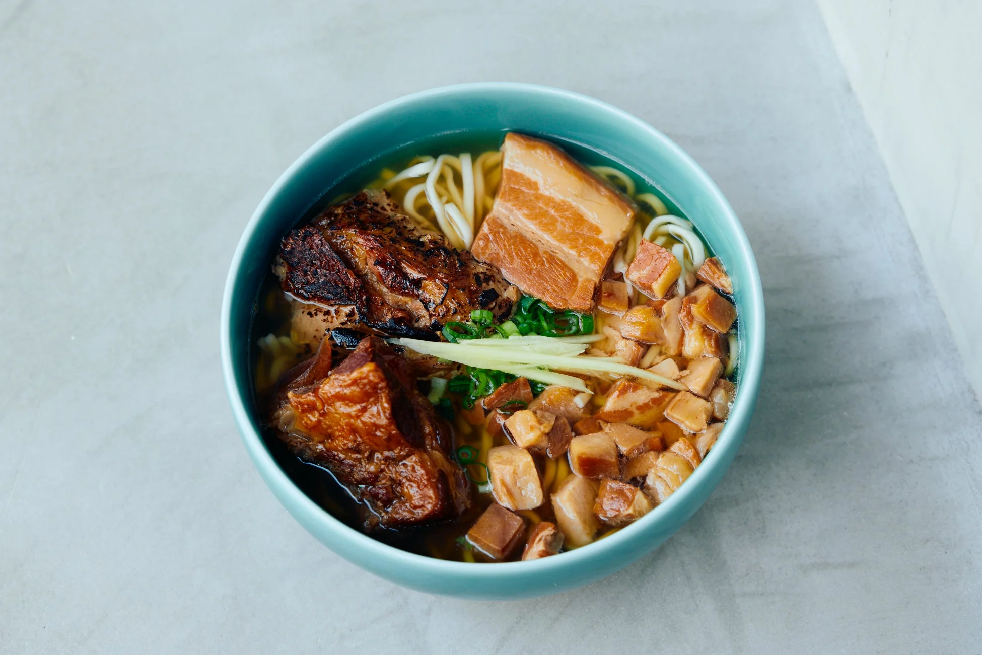 水色の器に入った沖縄そばのアップ。豚の角煮など