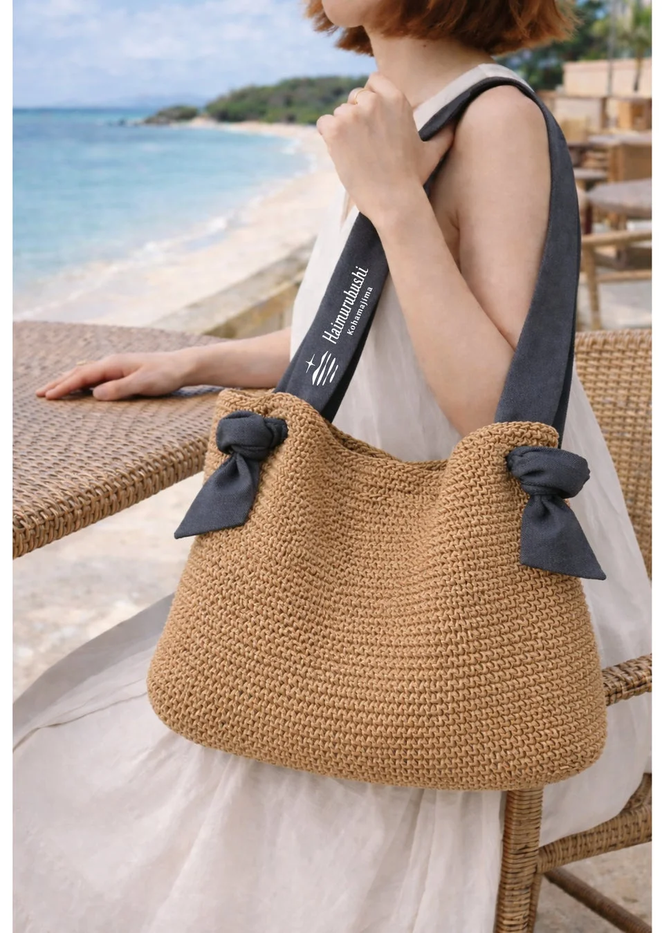 ビーチを背景に、麦わら素材のバッグを持つ女性