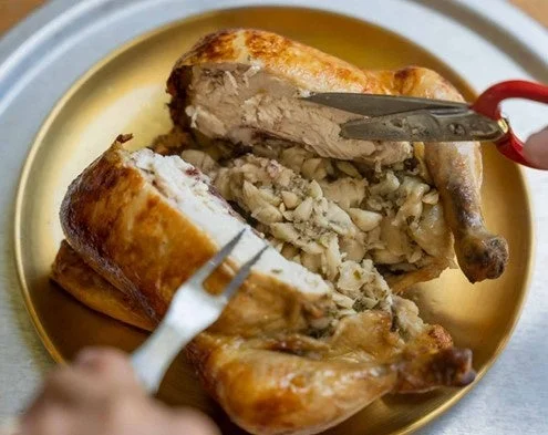 金色の皿に盛られた丸ごとのローストチキン