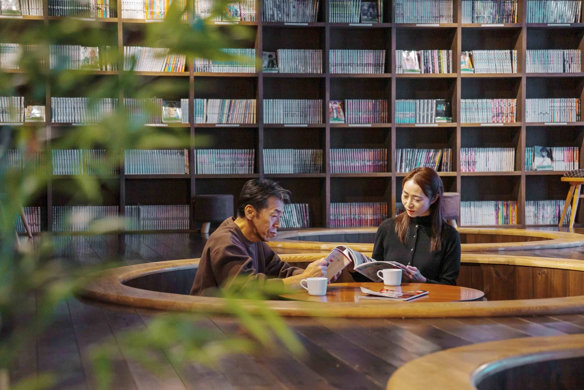 本棚に囲まれたラウンジで読書をする人々