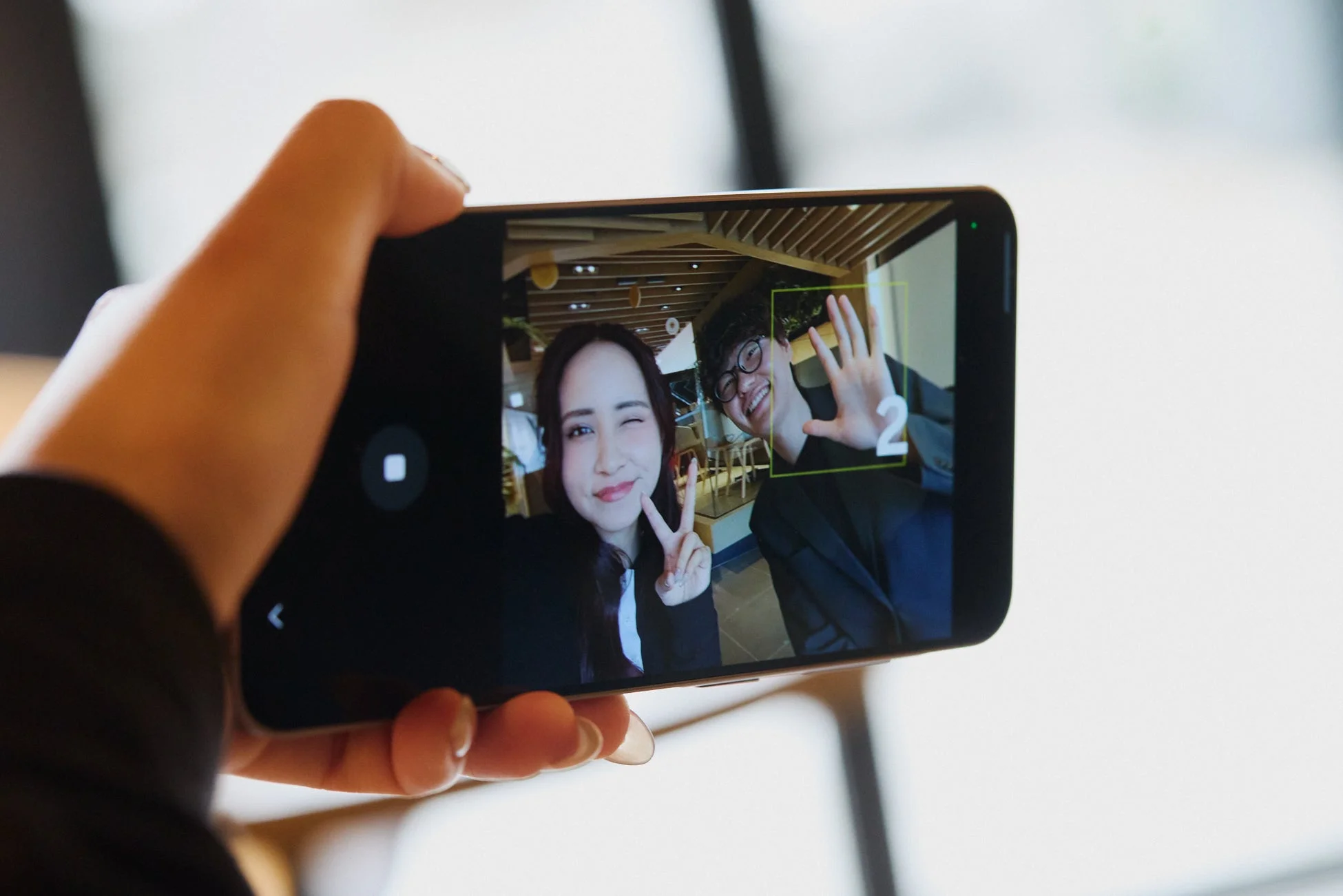 スマートフォンで自撮りをする男女の様子