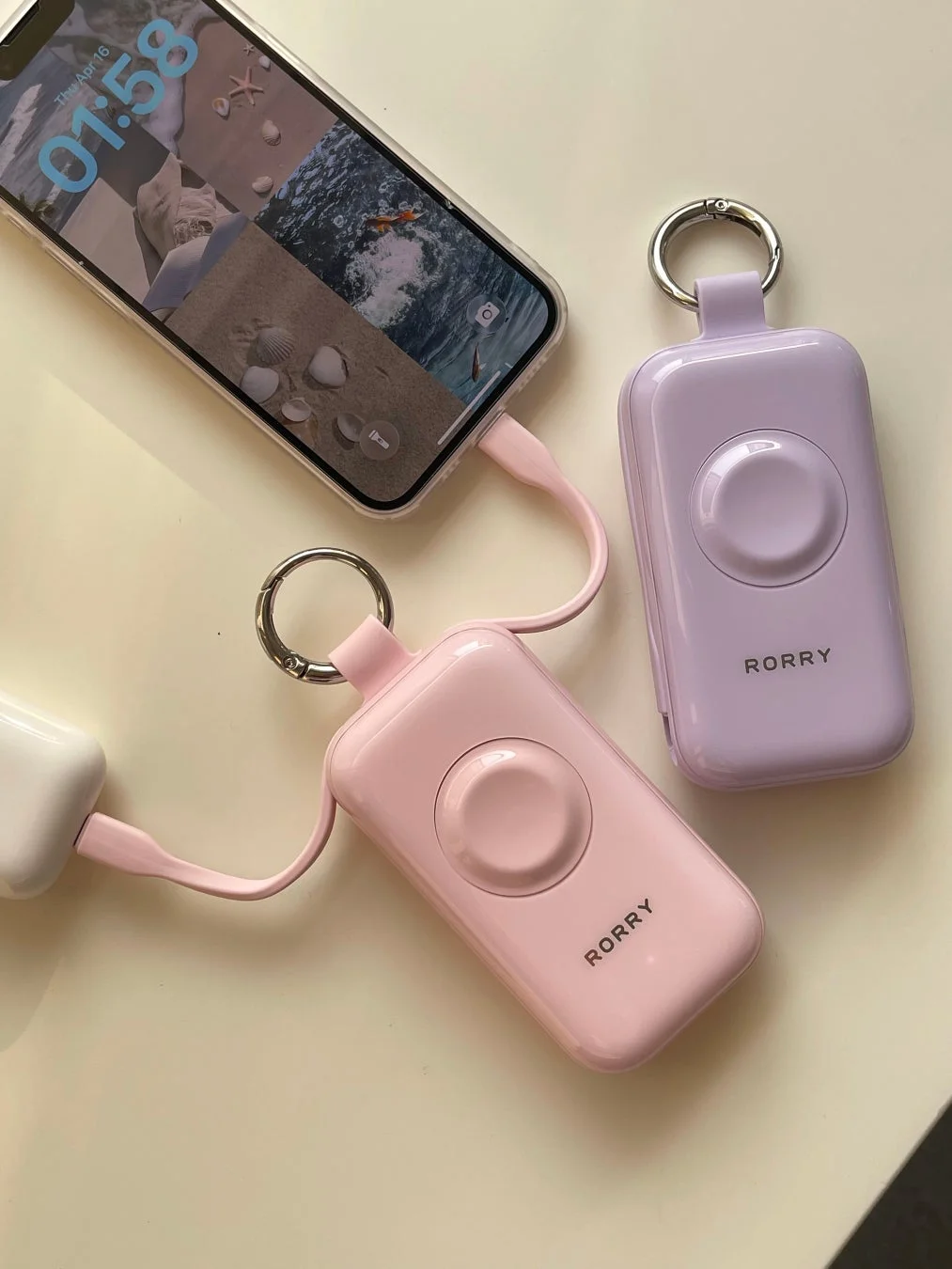 スマートフォンがピンクのポータブル充電器で充電されている様子