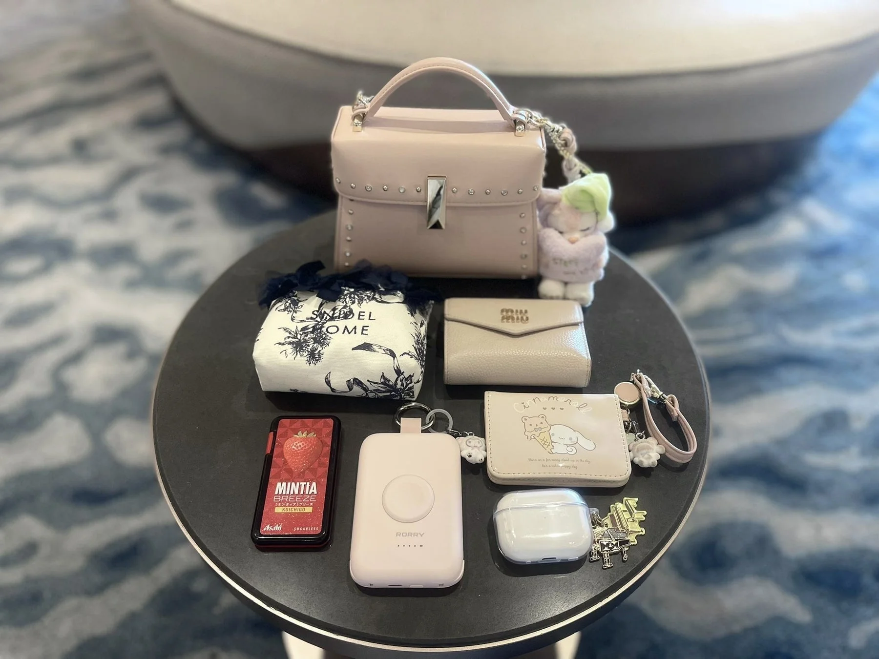 パステルカラーのバッグや財布、ポーチ、充電器など、女性の可愛らしい持ち物