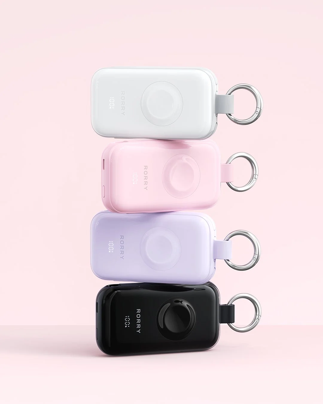 白、ピンク、紫、黒の4色のポータブル充電器が積み重ねて置かれている