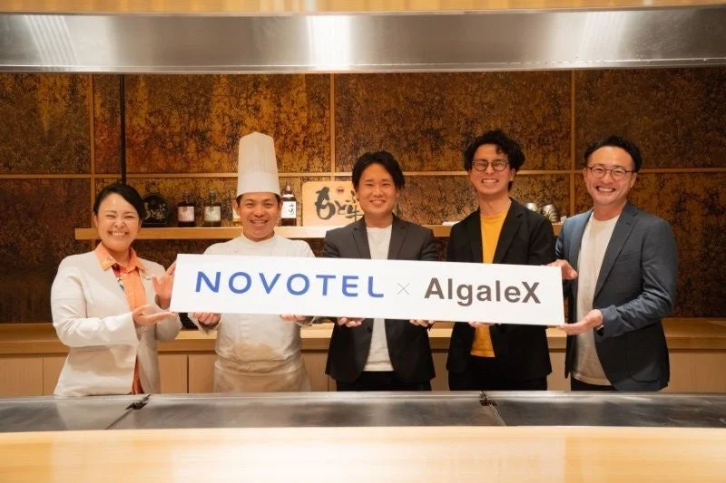 NOVOTEL x AlgaleXのバナーを持つ人々