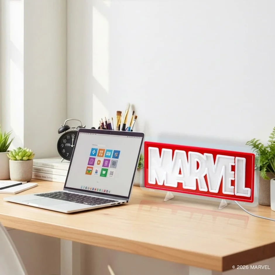 デスクに置かれたMARVELロゴのLEDネオンライトとノートパソコン