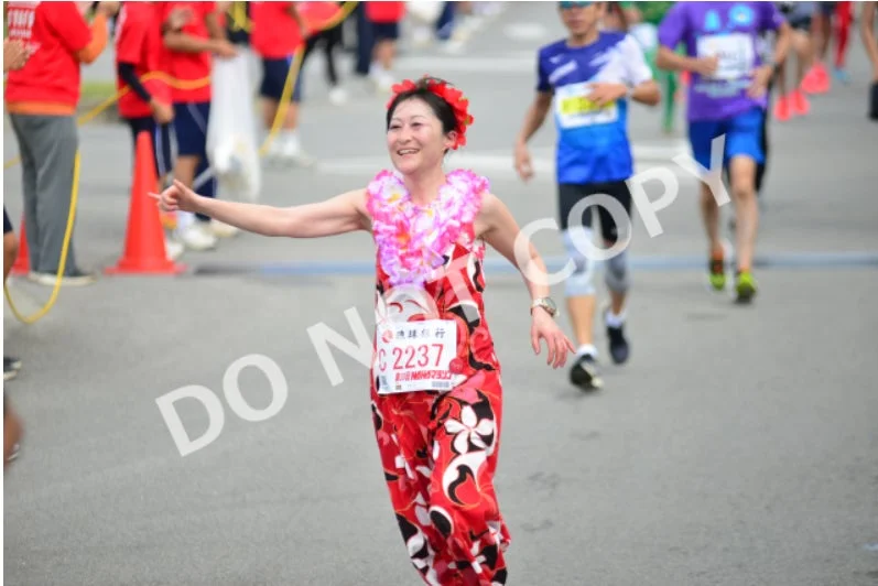 笑顔でマラソンを走る女性ランナー