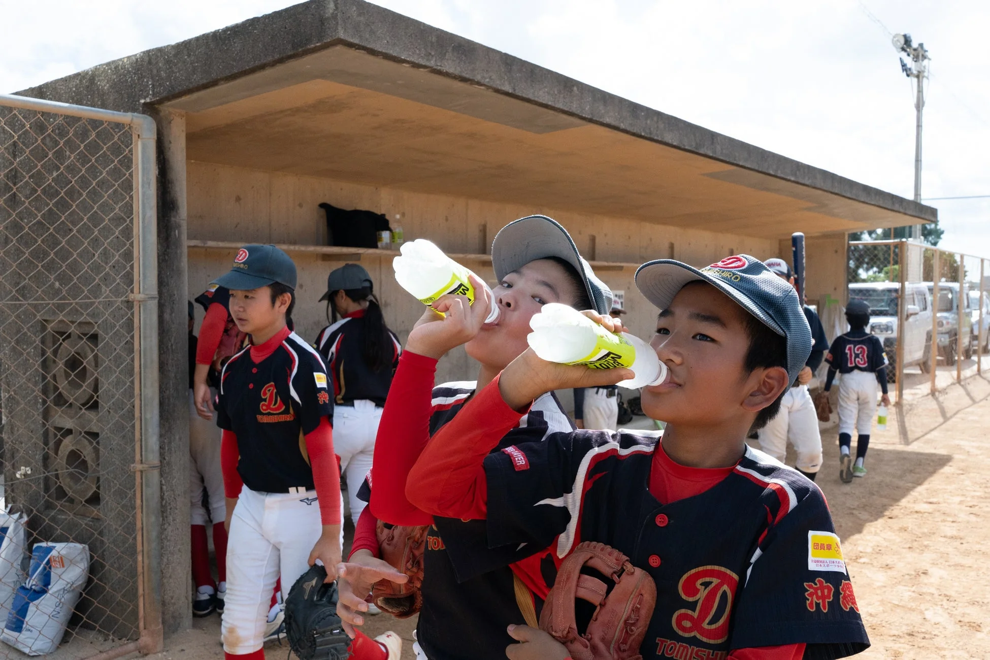休憩中に水分補給をする少年野球選手