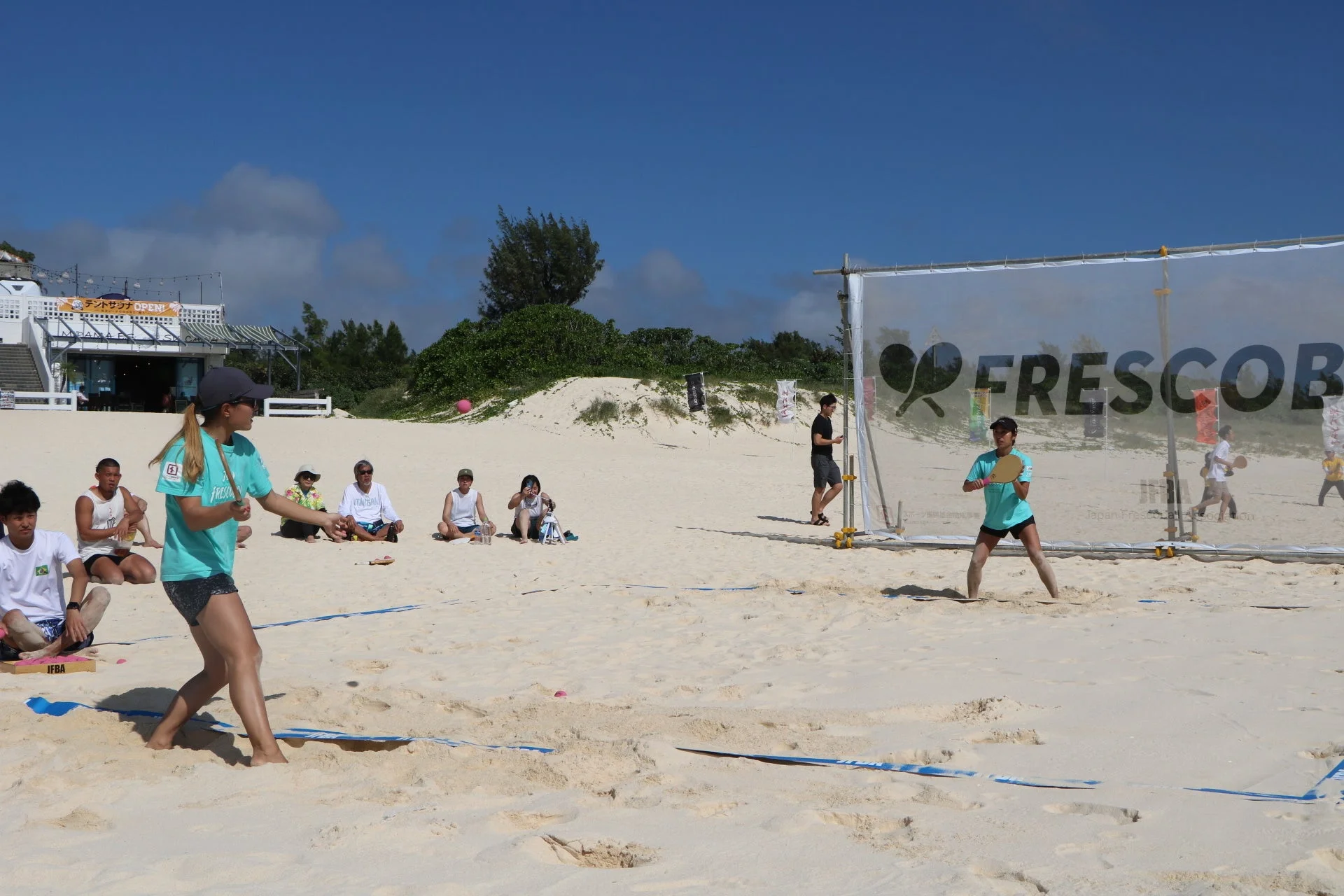 ビーチでフレスコボールを楽しむ人々