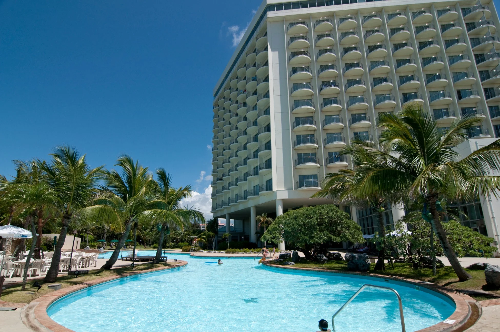 大きなホテルと曲線的なプールが広がるリゾート地の風景