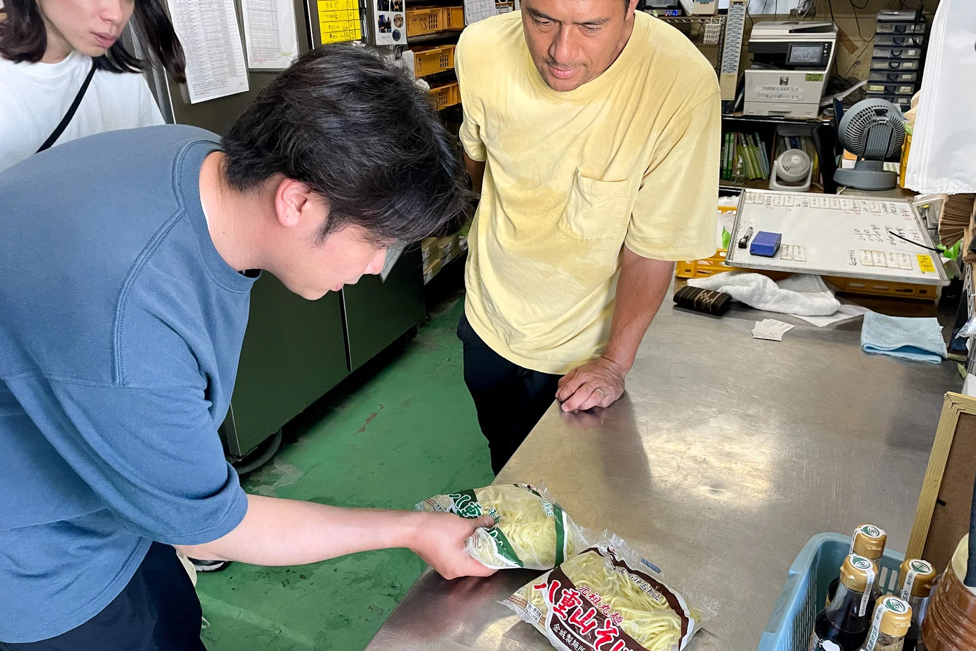 製麺所で打ち合わせをする男性たち