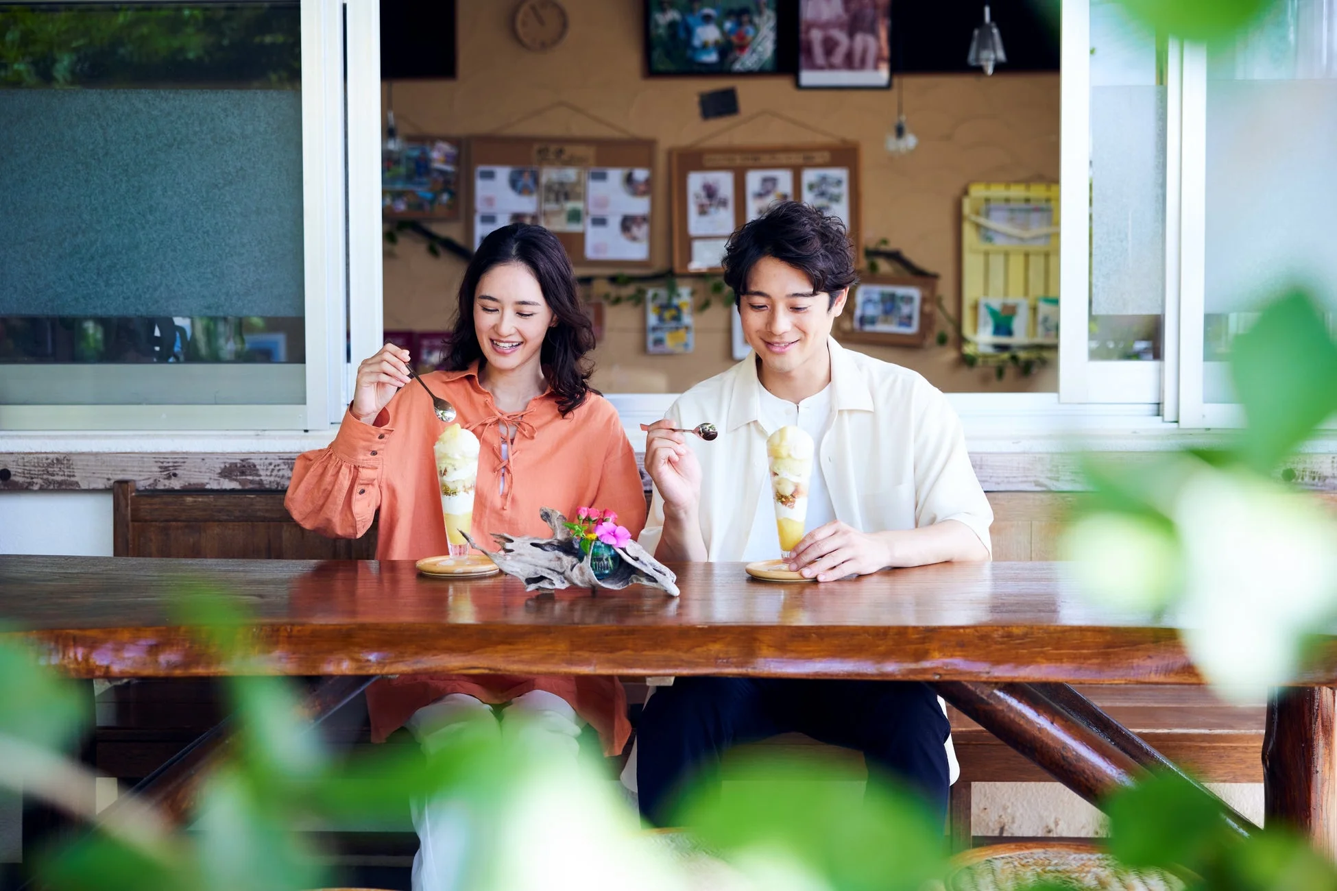 カフェでパフェを楽しむ笑顔の男女