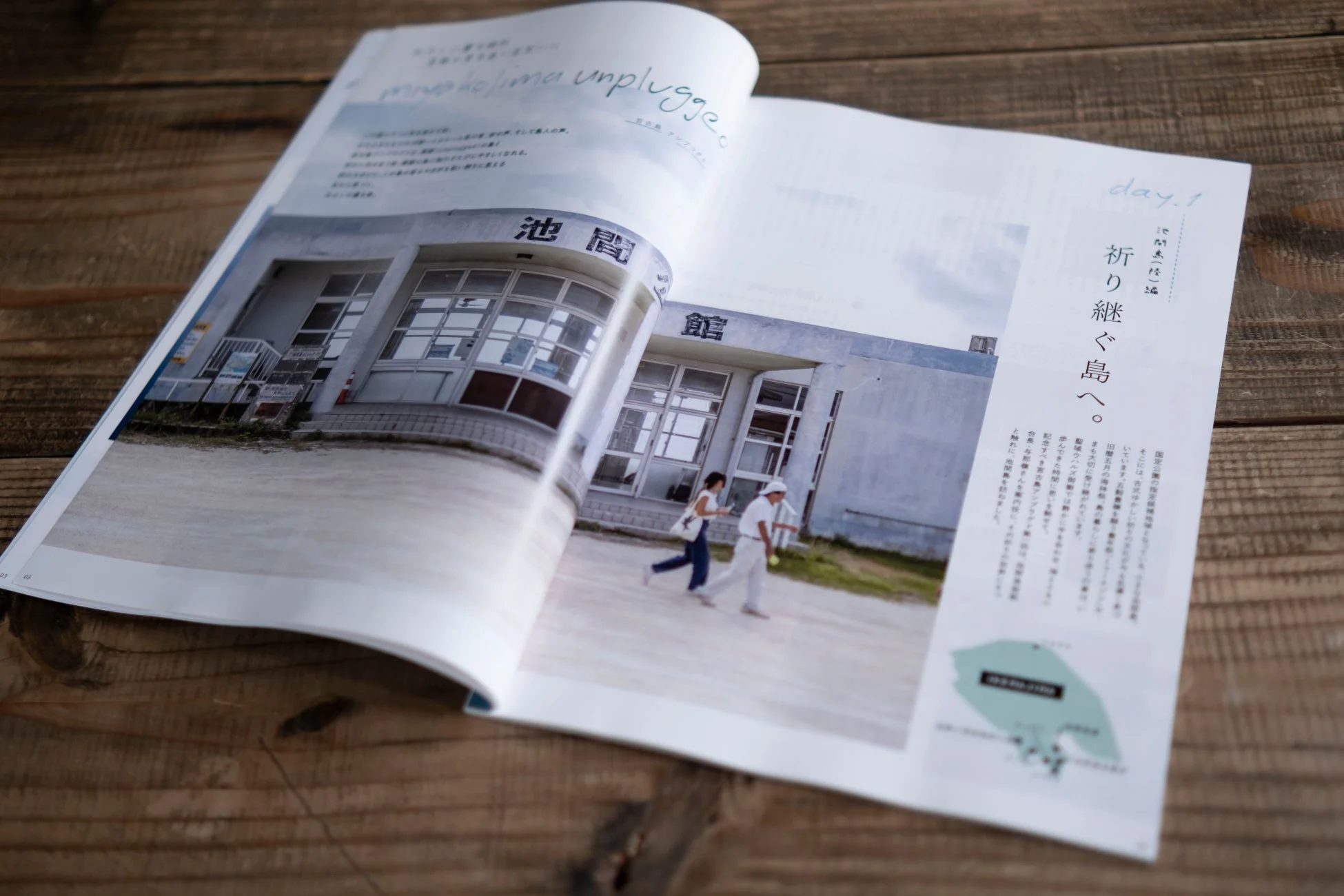 木製のテーブルに広げられた雑誌のページ、池間島をテーマにした記事