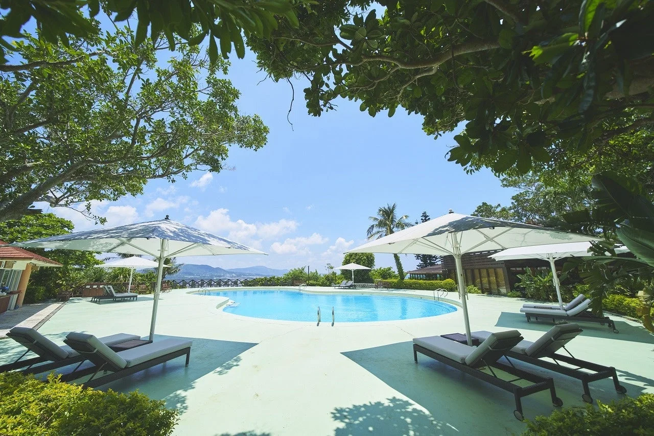 青空の下、リゾートホテルの屋外プールエリア