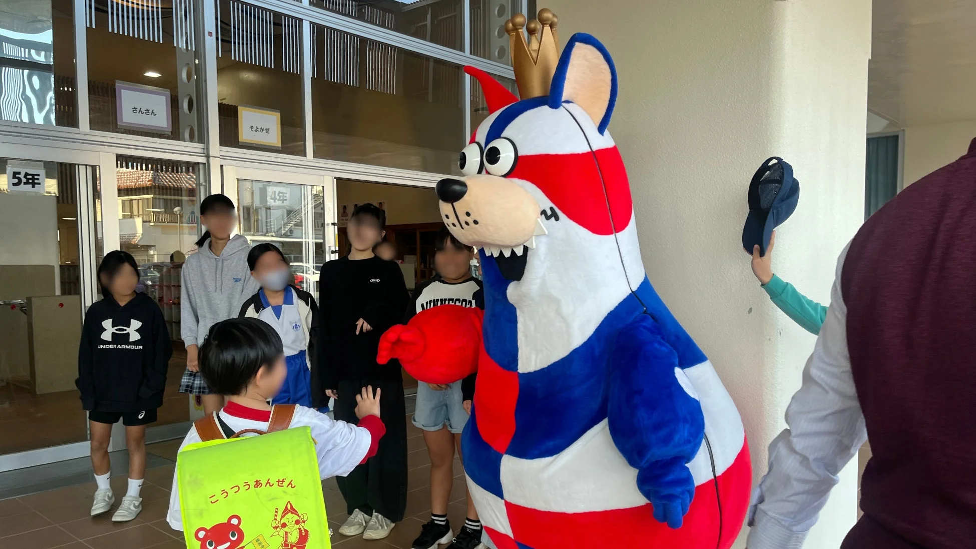 ゴーディーが小学校の入り口で子どもたちと交流