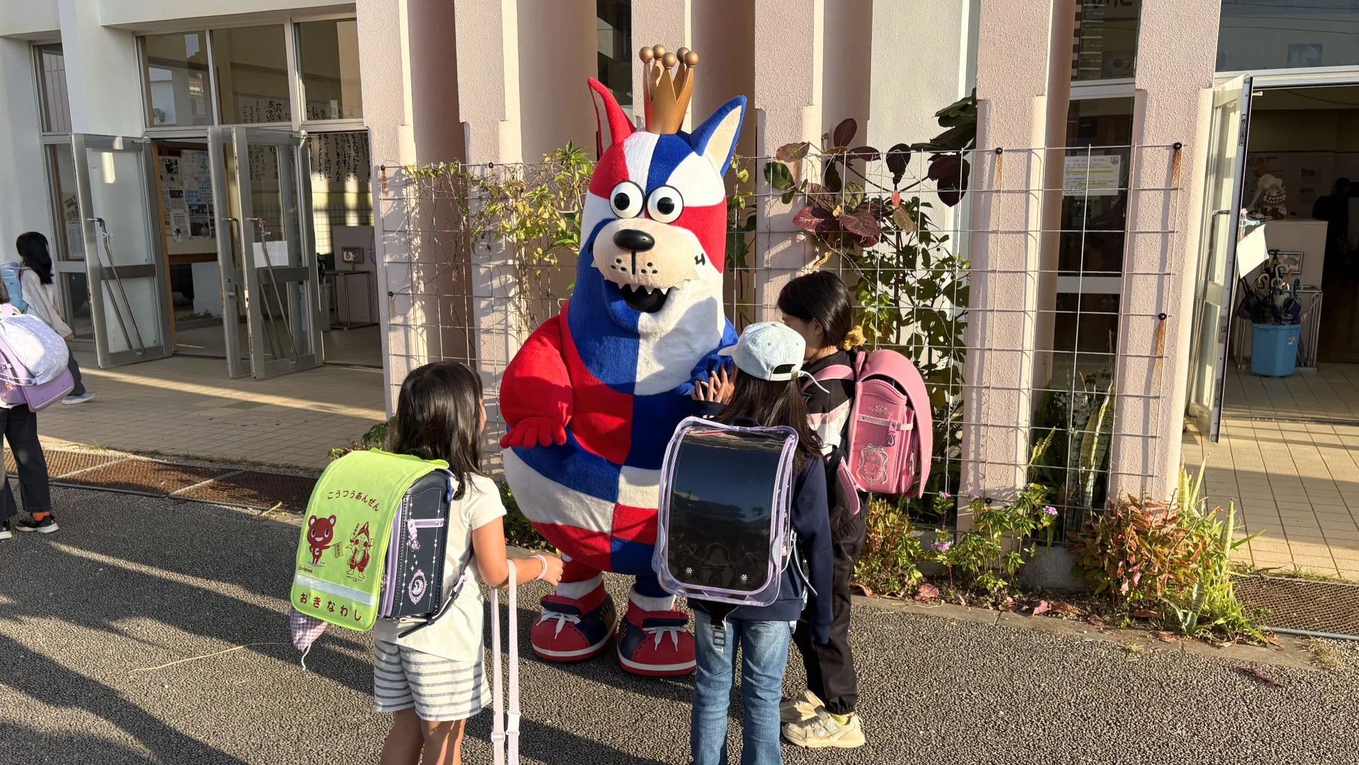 ゴーディーと子どもたちが交通安全のメッセージの前で交流
