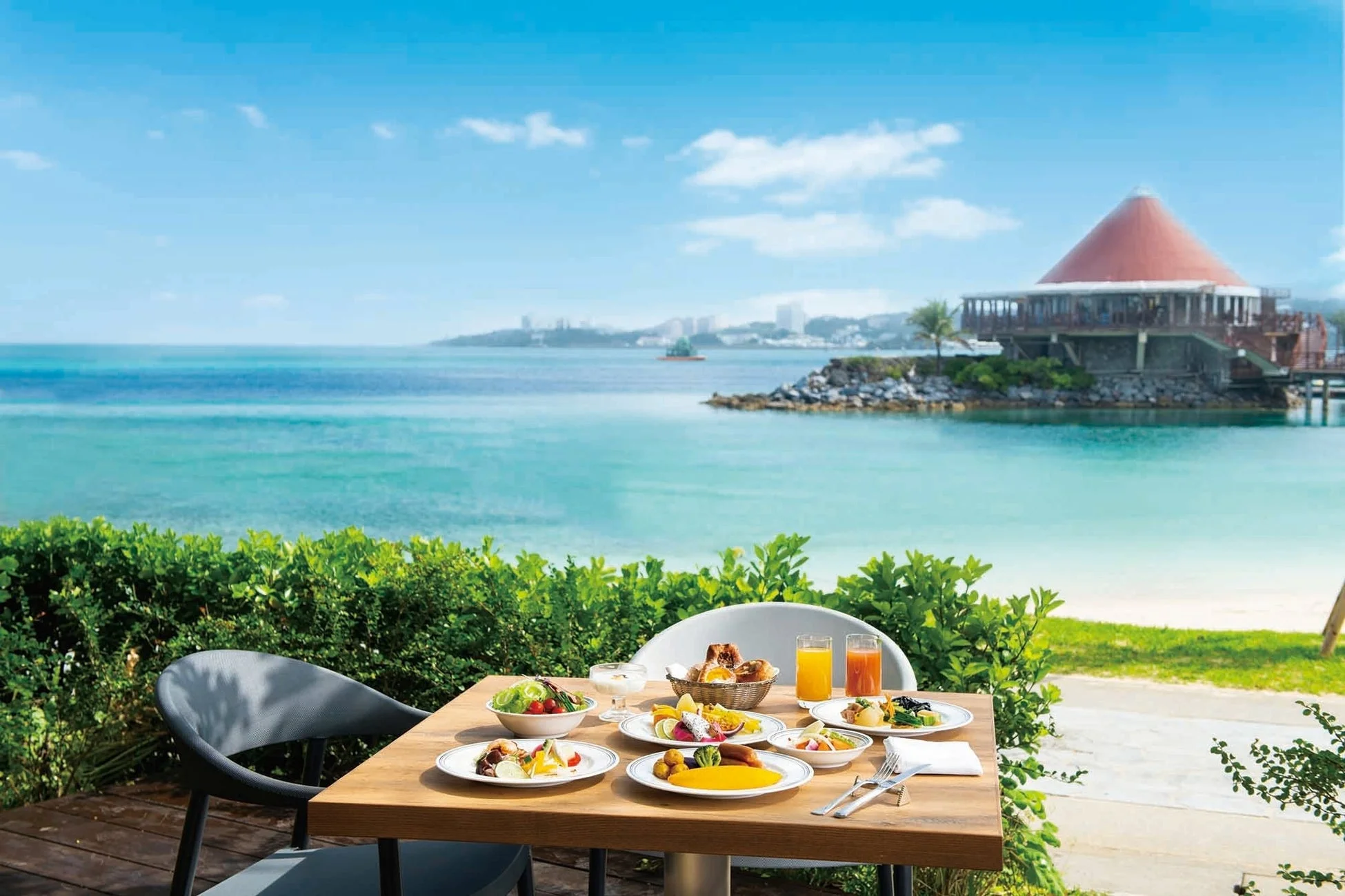 美しい海と空が広がる屋外テラスでの朝食