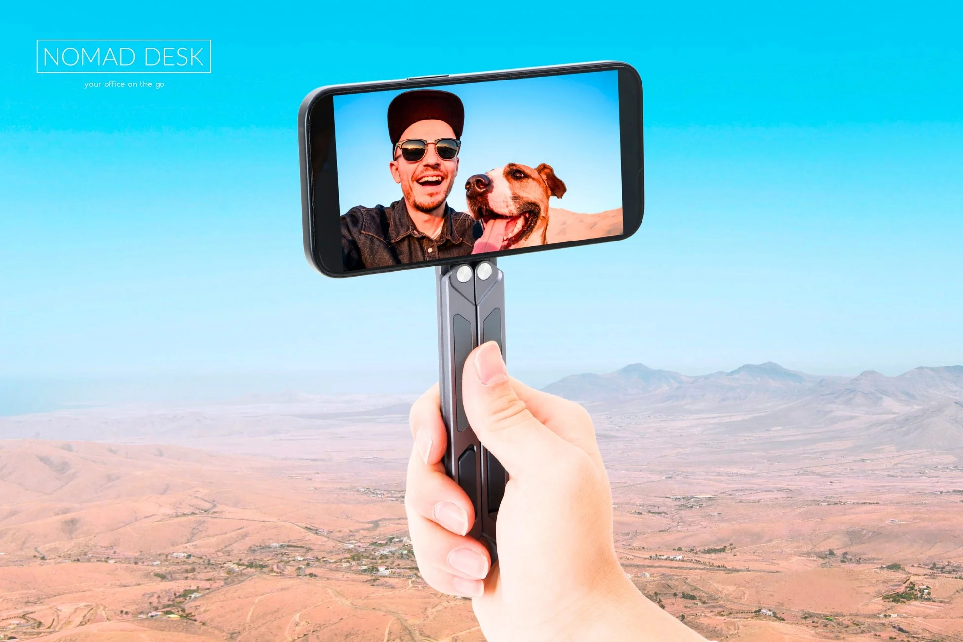 自撮り棒に装着されたスマートフォンで男性と犬がセルフィーを撮る様子