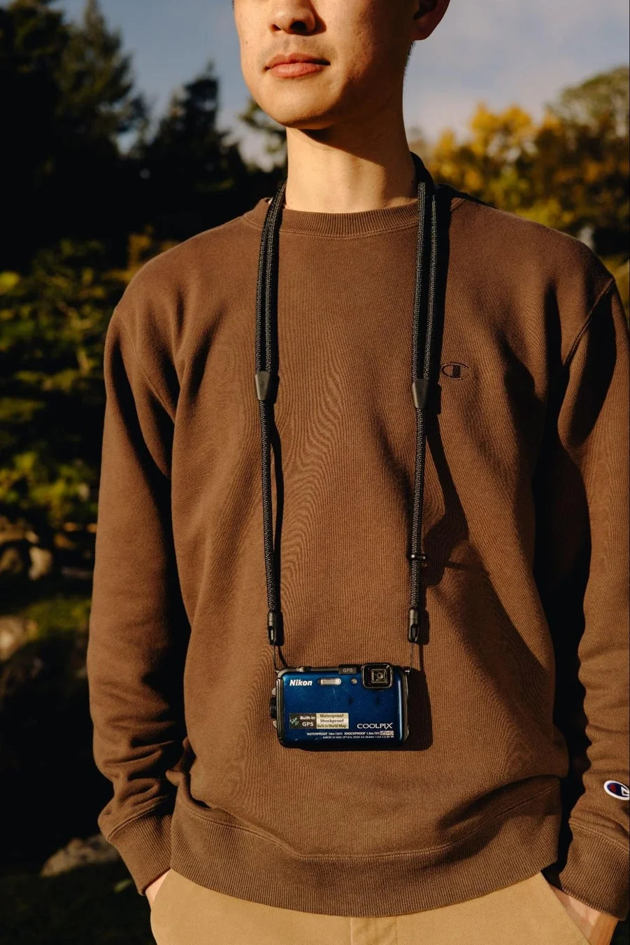 男性がカメラを下げている