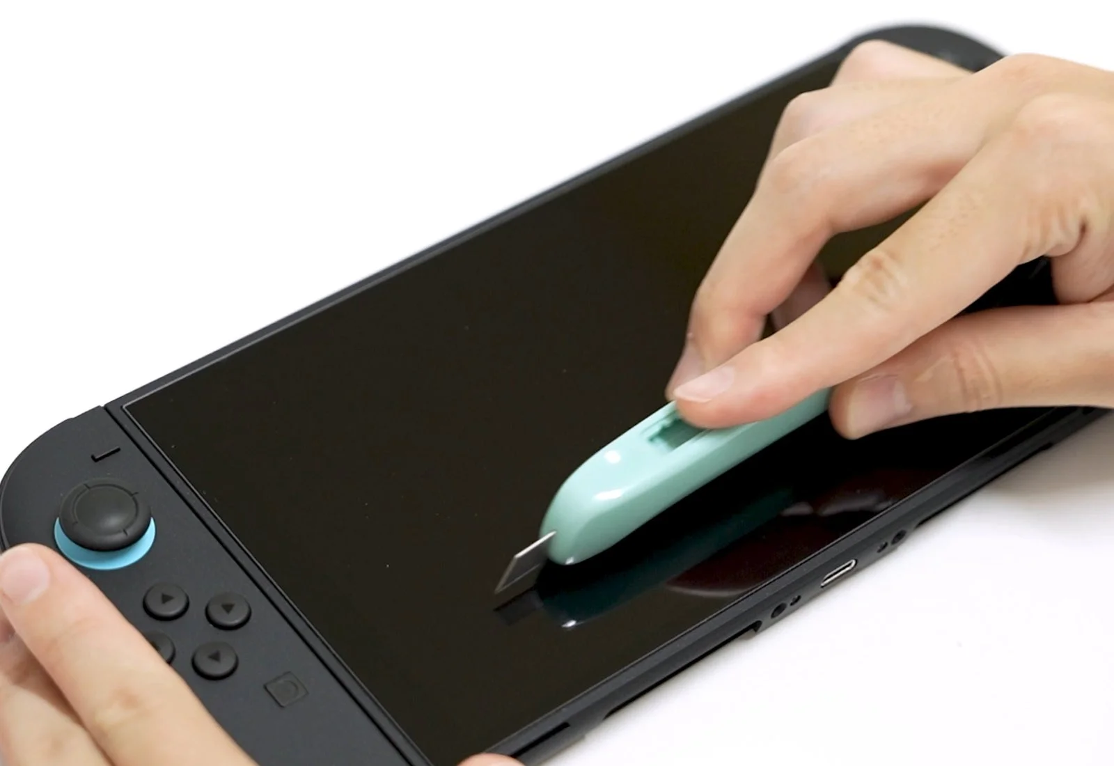 カッターナイフで画面を試す様子