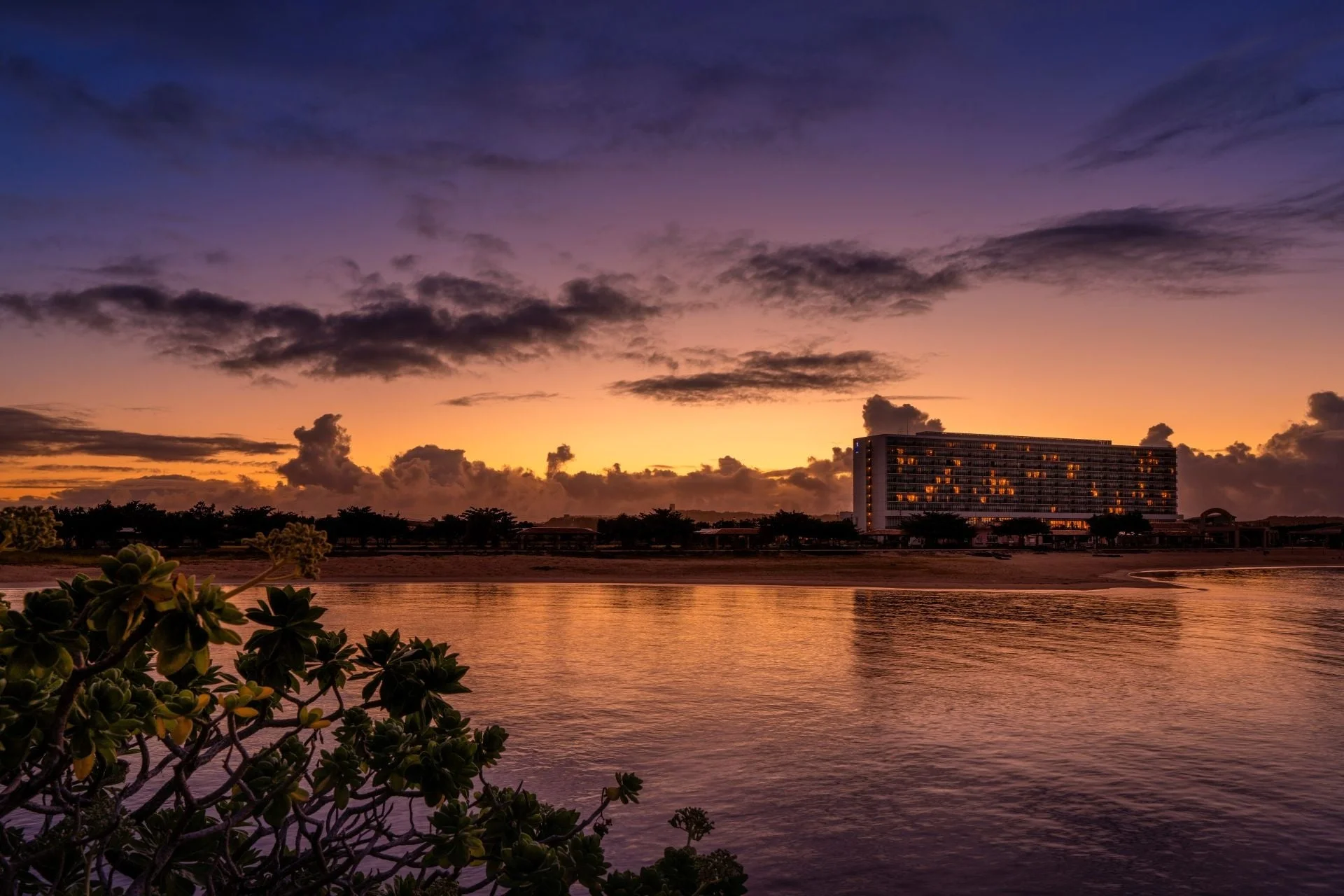 夕焼けに染まる海とホテル
