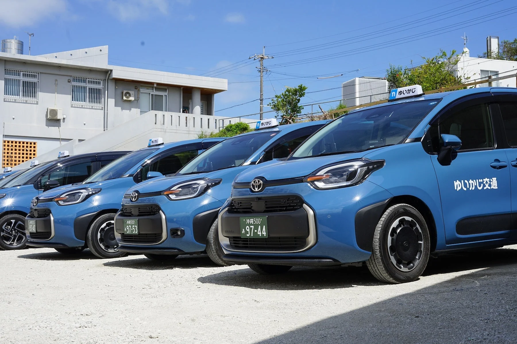 青いトヨタ シエンタのタクシーが複数台、一列に駐車されている様子