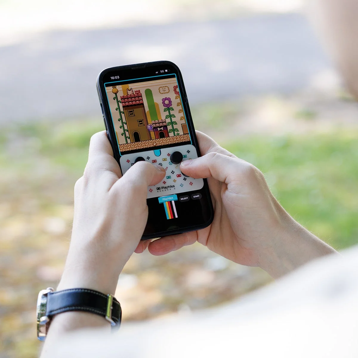 スマホでPlaytilesを使ってゲームをプレイしている手元