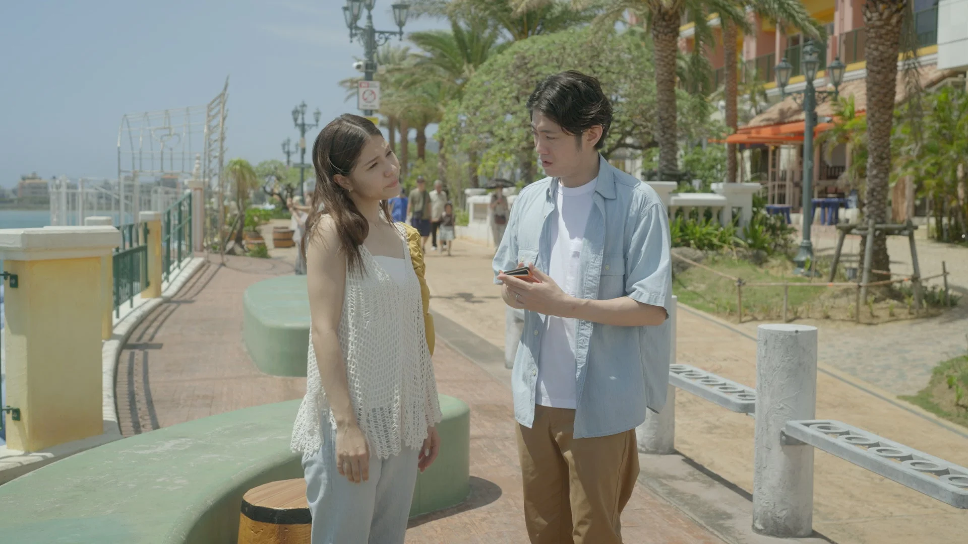 晴れた日にリゾート地のような屋外で会話をする若い男女