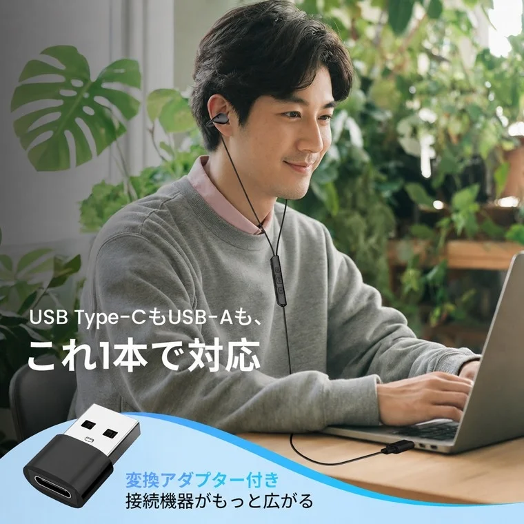 ノートパソコンを使用中の男性が有線イヤホンを装着している画像