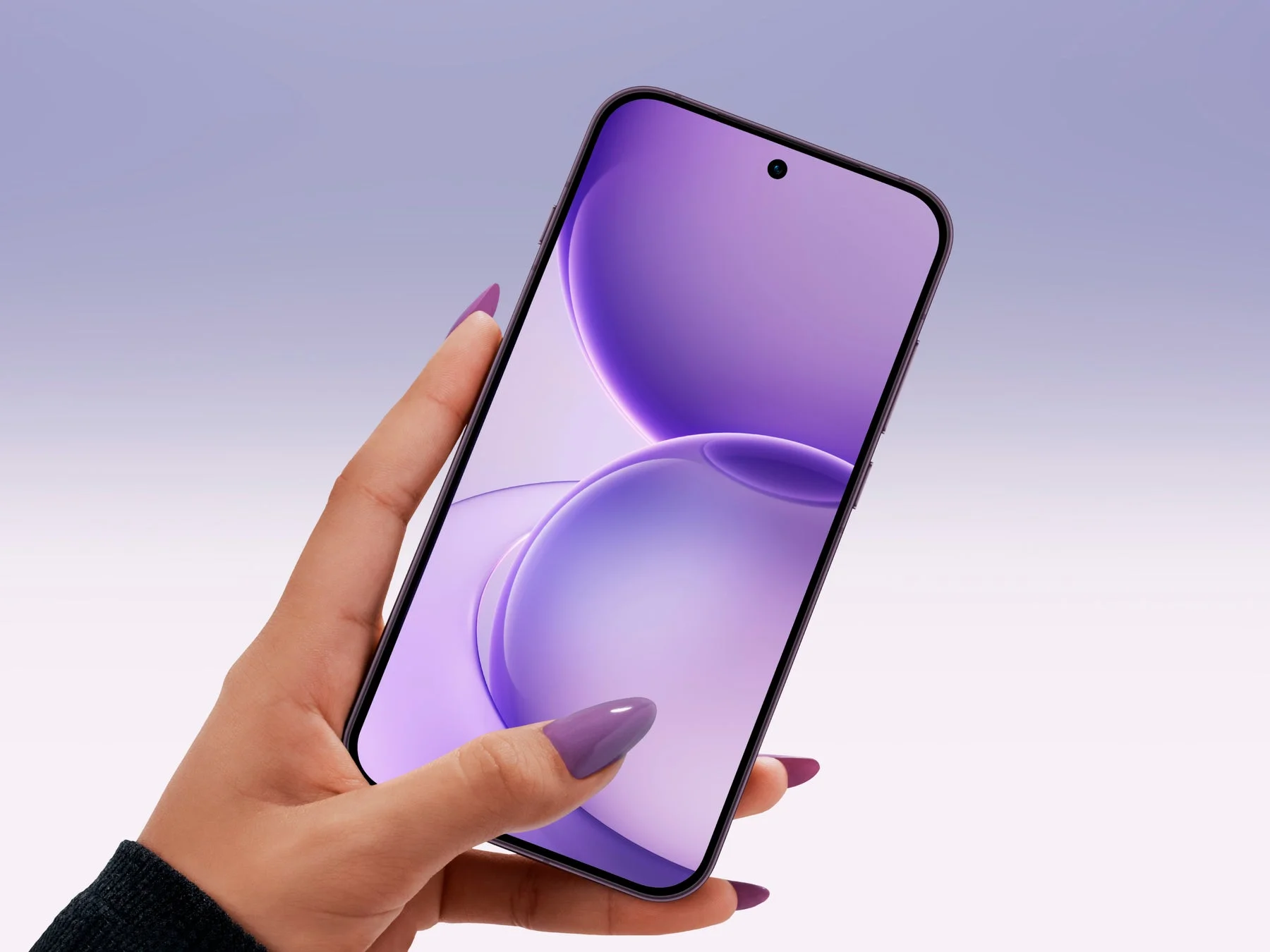 紫色のネイルを施した手がスマートフォンを持っている
