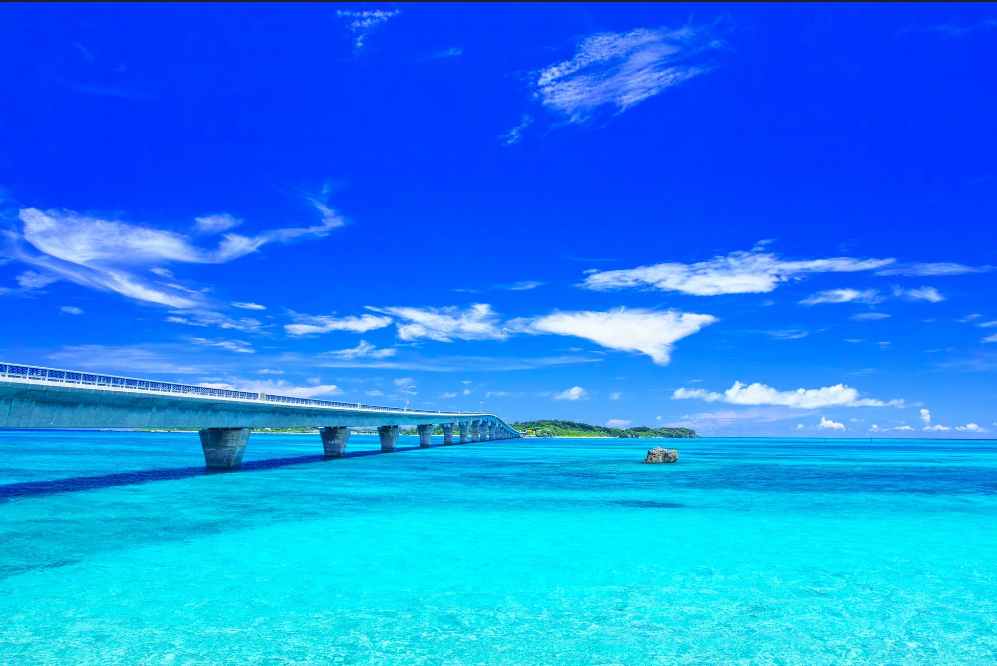 エメラルドグリーンの美しい海と、その上を伸びる長い橋